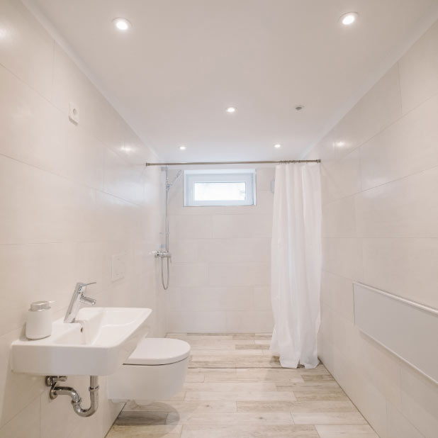 A personal changing room with shower and toilet.